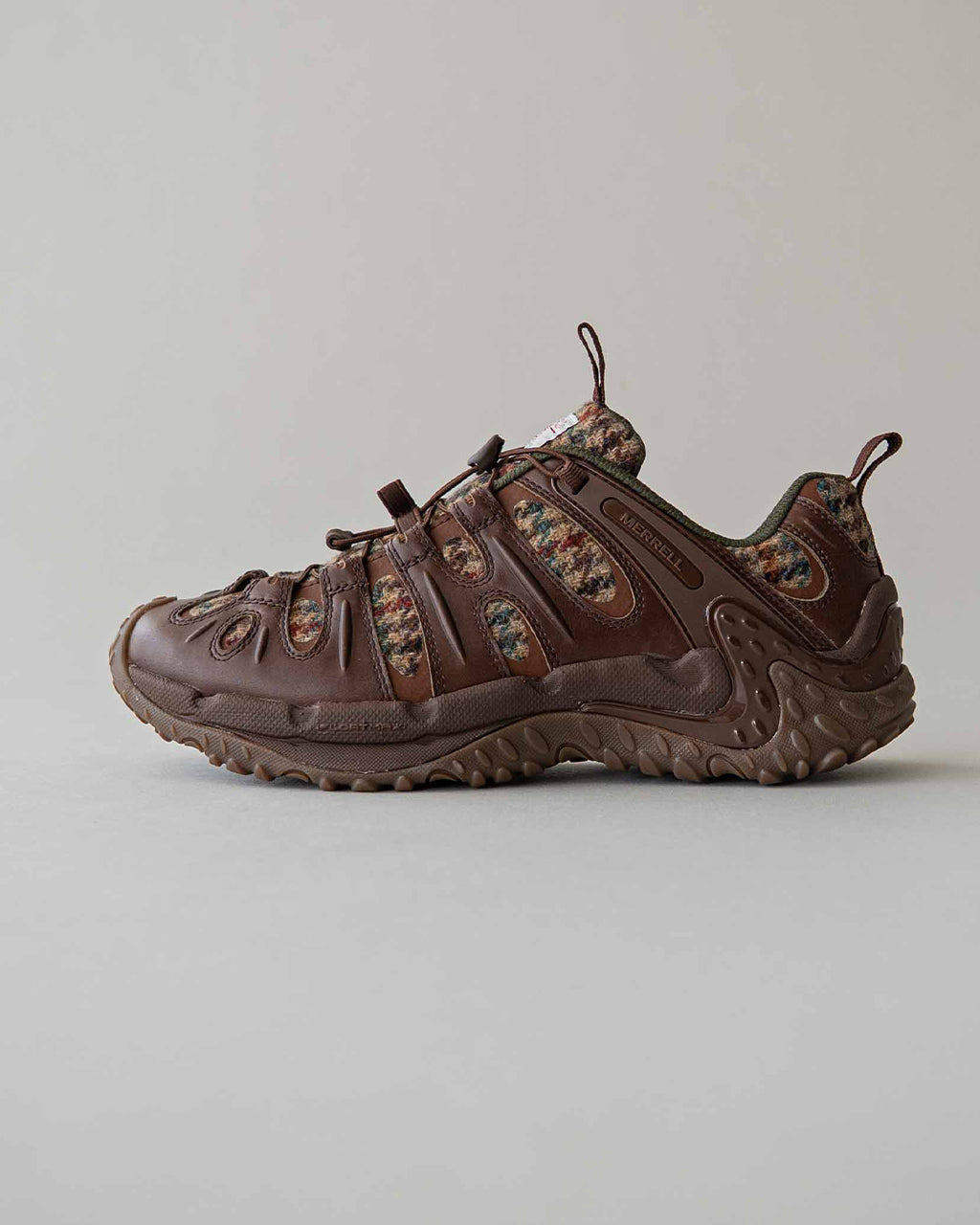 ダークウォルナットカラーのハリスツイードとレザーの組み合わせが特徴的な MERRELL チャンレモンレダックス風スニーカー風のアウトドアシューズ。側面に通気性の切替と堅牢なソール、靴紐はトグル式で調整しやすい作りです。