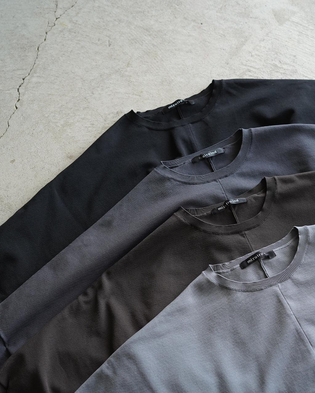 mizuiro ind cocoon P/Oの前後が分かるクルーネックのニット。ブラック系からグレー系までの4色展開で、生地は滑らかなポリエステルニット。首まわりはリブ仕様で袖口もゆったりとしたドロップショルダーのデザインが特徴。