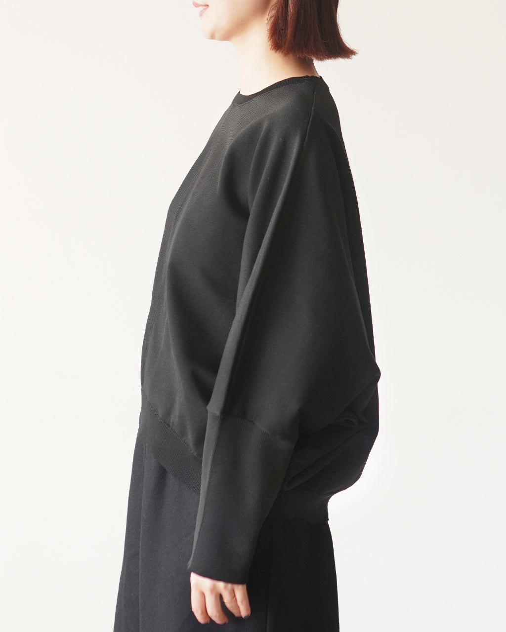 mizuiro indの cocoon P/O の着用側面写真。黒系のビッグシルエットニット。袖口と裾にリブが施され、ドルマンスリーブの特徴がわかる横姿。
