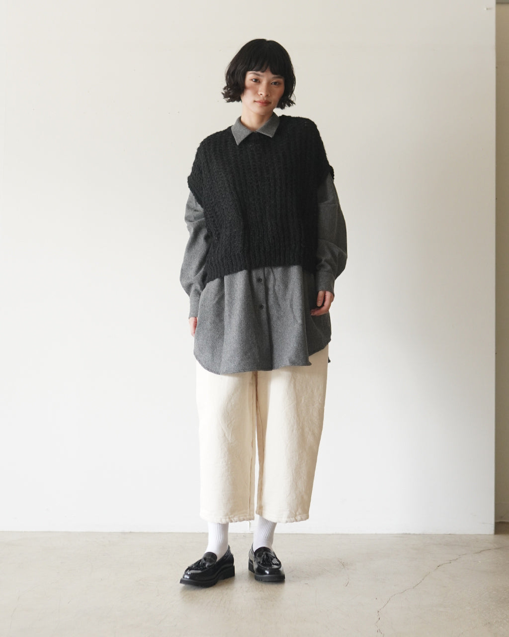 黒のニットベストを重ねたグレーのシャツコーディネート。前身頃が立体感のある編み地で、裾へ向かってゆるやかに広がってすぼまるコクーンシルエットが特徴です
