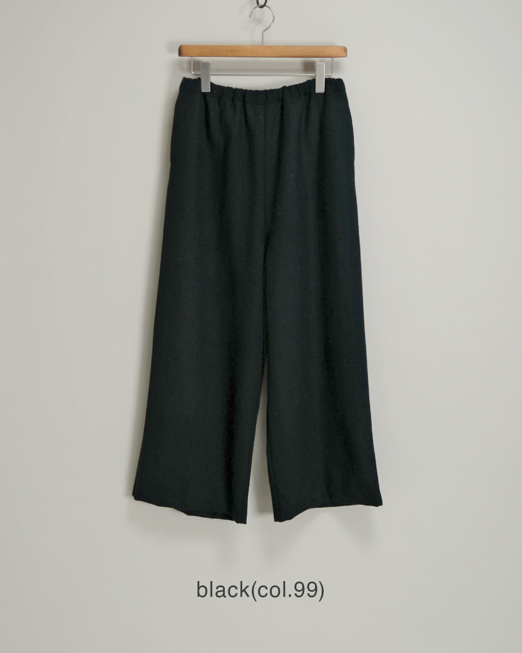 mizuiro ind wool wide easy PTのブラック系カラーをハンガーに掛けたパンツの正面全体像。ウエストはゴム仕様で、ゆったりとしたワイドシルエットが分かる。