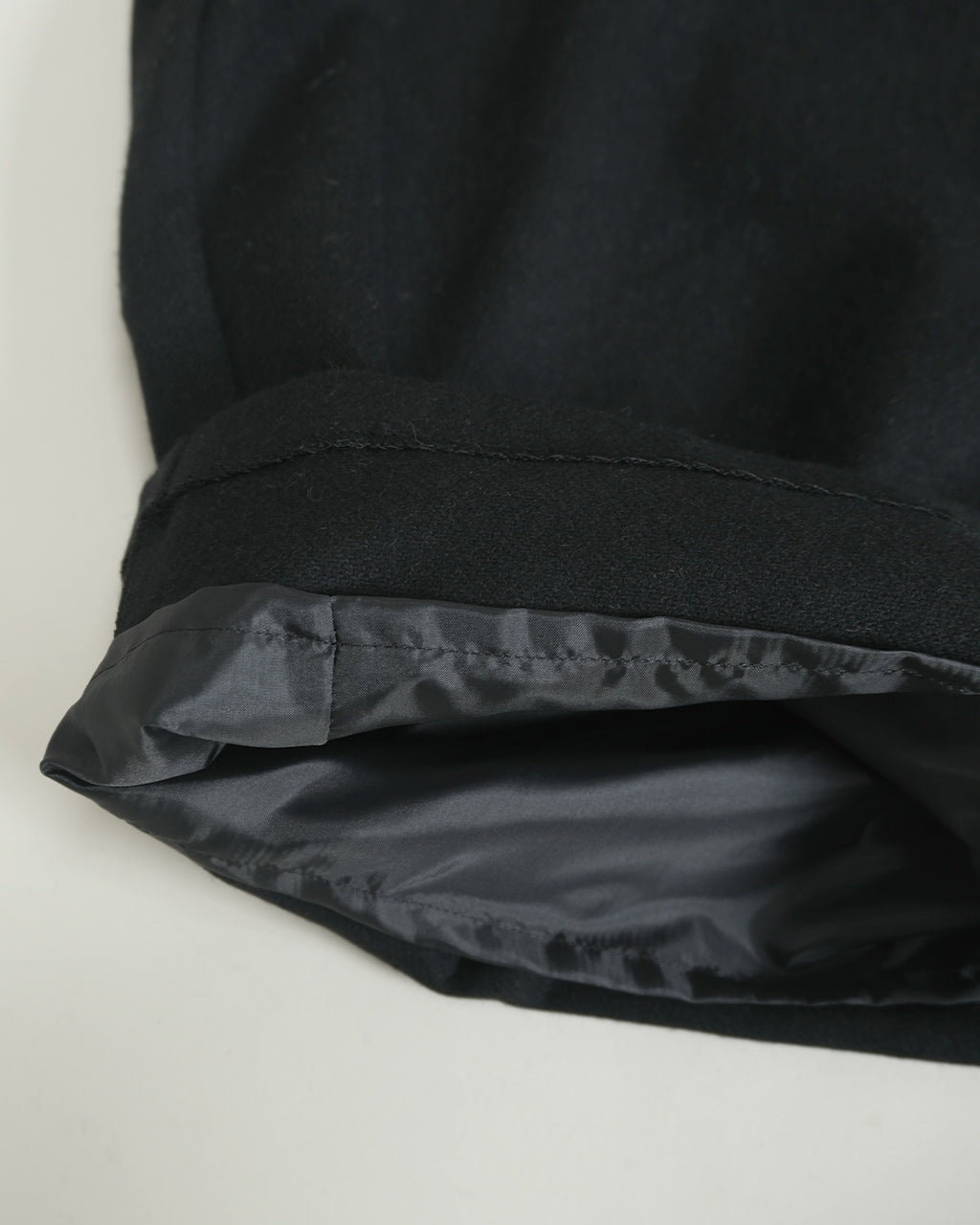 mizuiro indの wool wide easy PT。黒系の裾近くをアップで撮影したディテール showing ウール素材の質感と裾の裏地が見える画像
