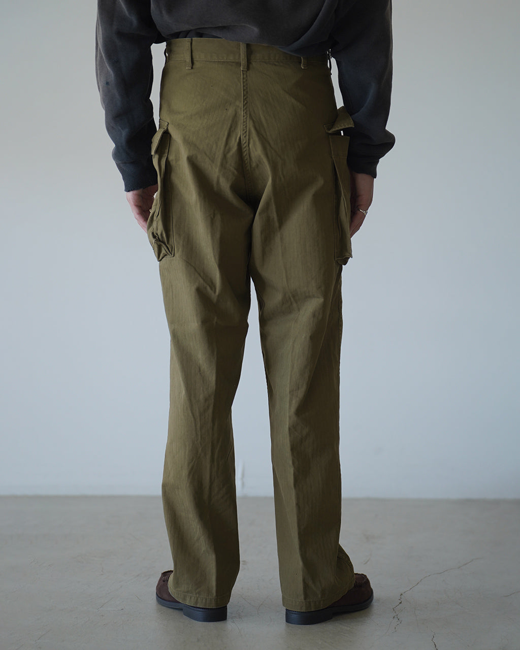 オアスロウのU.S ARMY 2 POCKET CARGO風カーゴパンツ、 olive系アーミーグリーンの後ろ姿。腰周りのディテールと大容量カーゴポケットが強調され、ワイドストレートのシルエットが分かる背面ビューです。