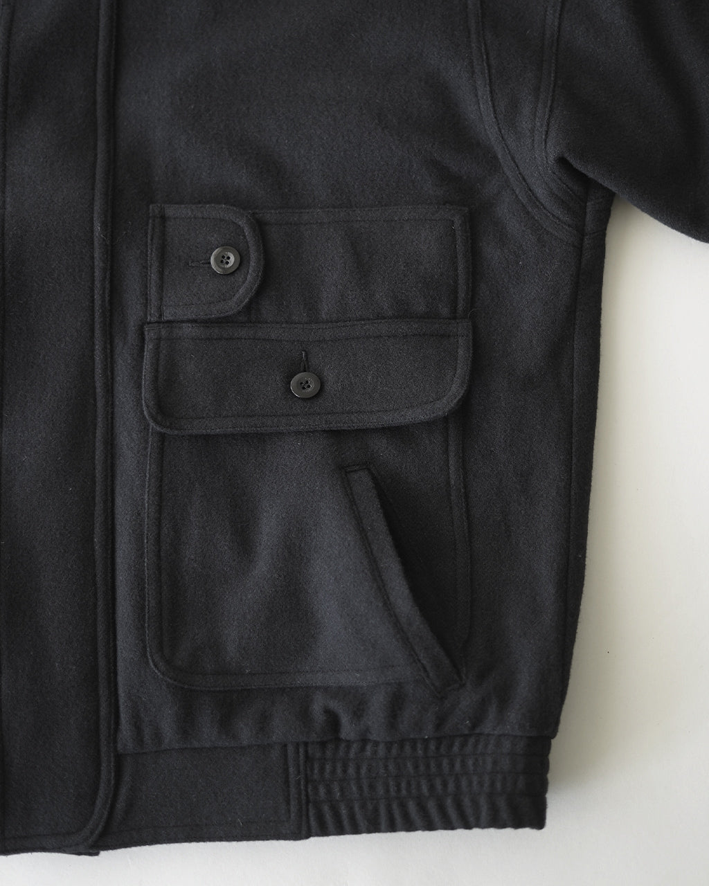チャコールカラーのVESTE ABOS OV-T055。前立ては比翼仕立て、胸ポケットと大きなフラップ付きポケットが特徴的なウールジャケットのアップショット。