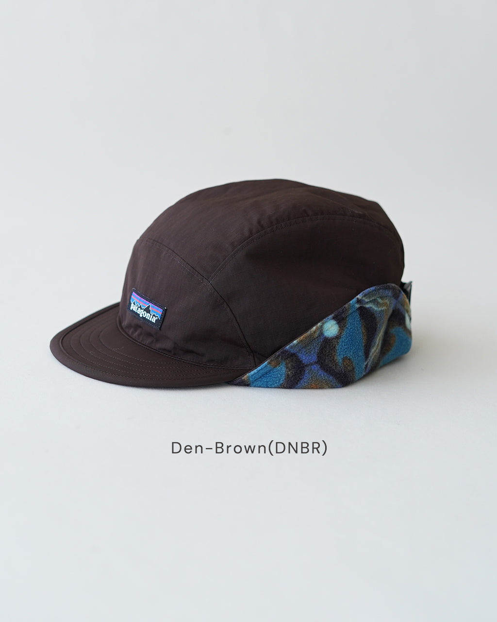 Den-Brown(DNBR)のフロント部分を覆う黒系の帽子。つばの縁と側面には幾何学模様のカラーアセント布をあしらい、パタゴニアのロゴが左前方に小さく配置されたデザインです。
