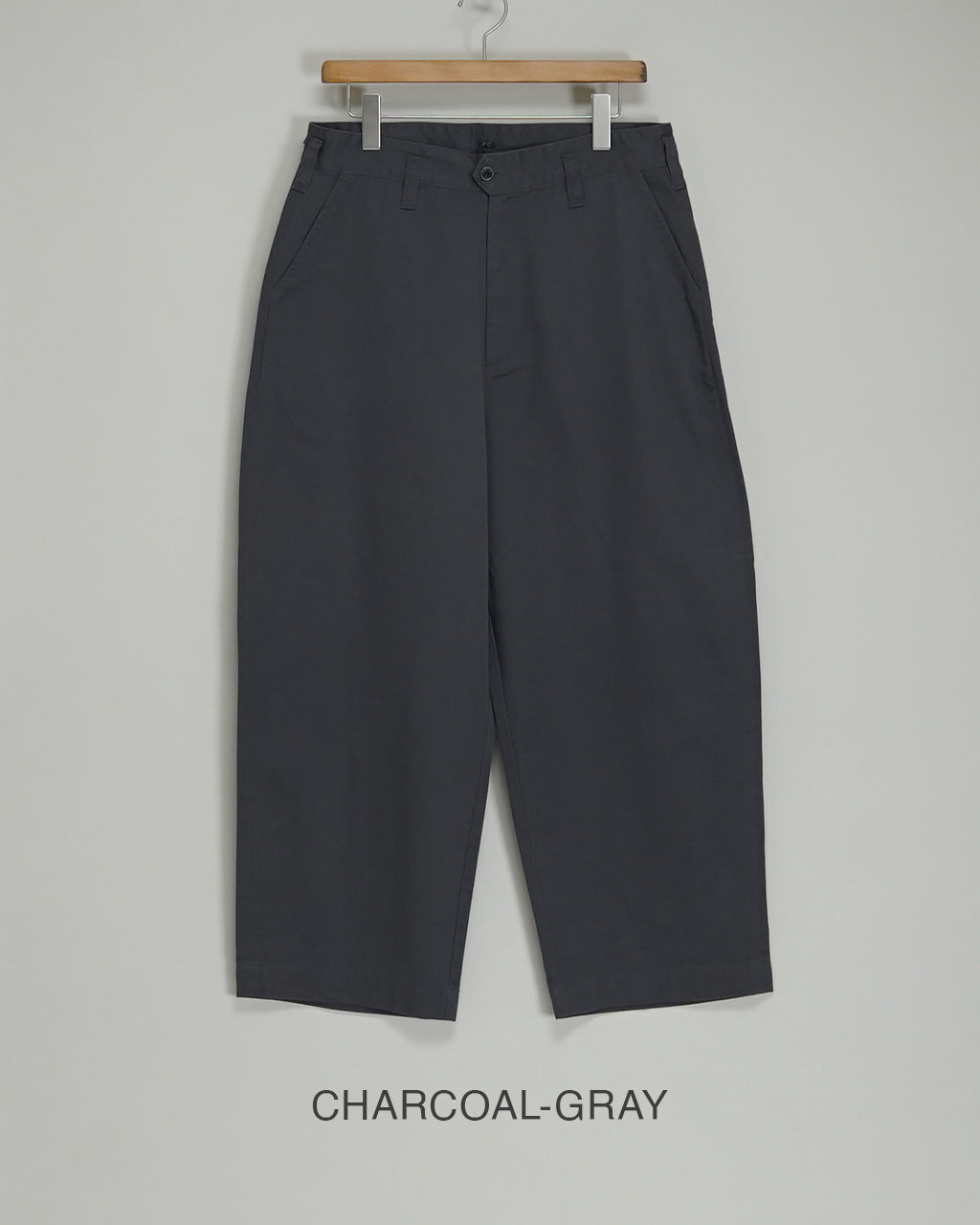 PORTER CLASSICのGENE KELLY CHINOS、グレー系のパンツがハンガーに掛かった正面写真。腰周りにゆとりがあり、裾に向かってやや細くなるテーパードシルエットが特徴。