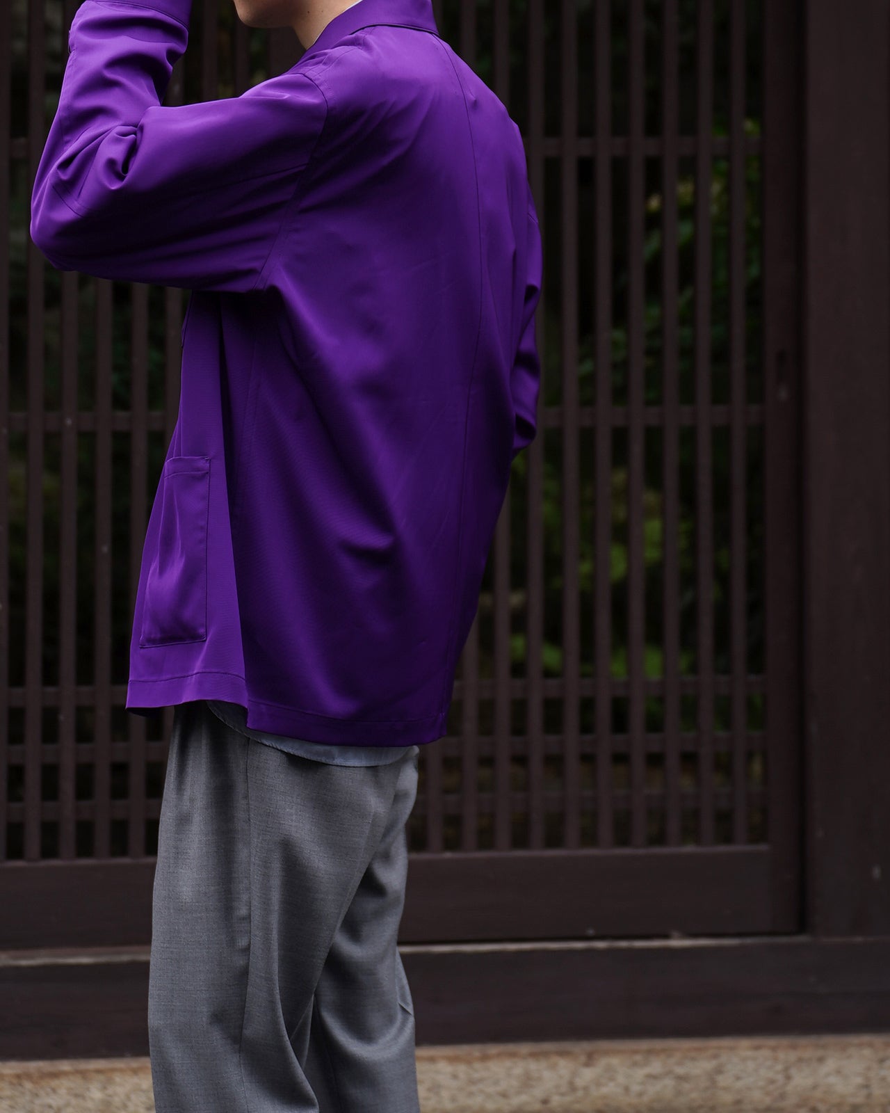 鮮やかなパープルのSUPPLE WORK SHIRTの背面と袖周りが映るシルエット写真。光沢のある生地とドレープ感が際立ち、裾は前後でやや長めに見える。