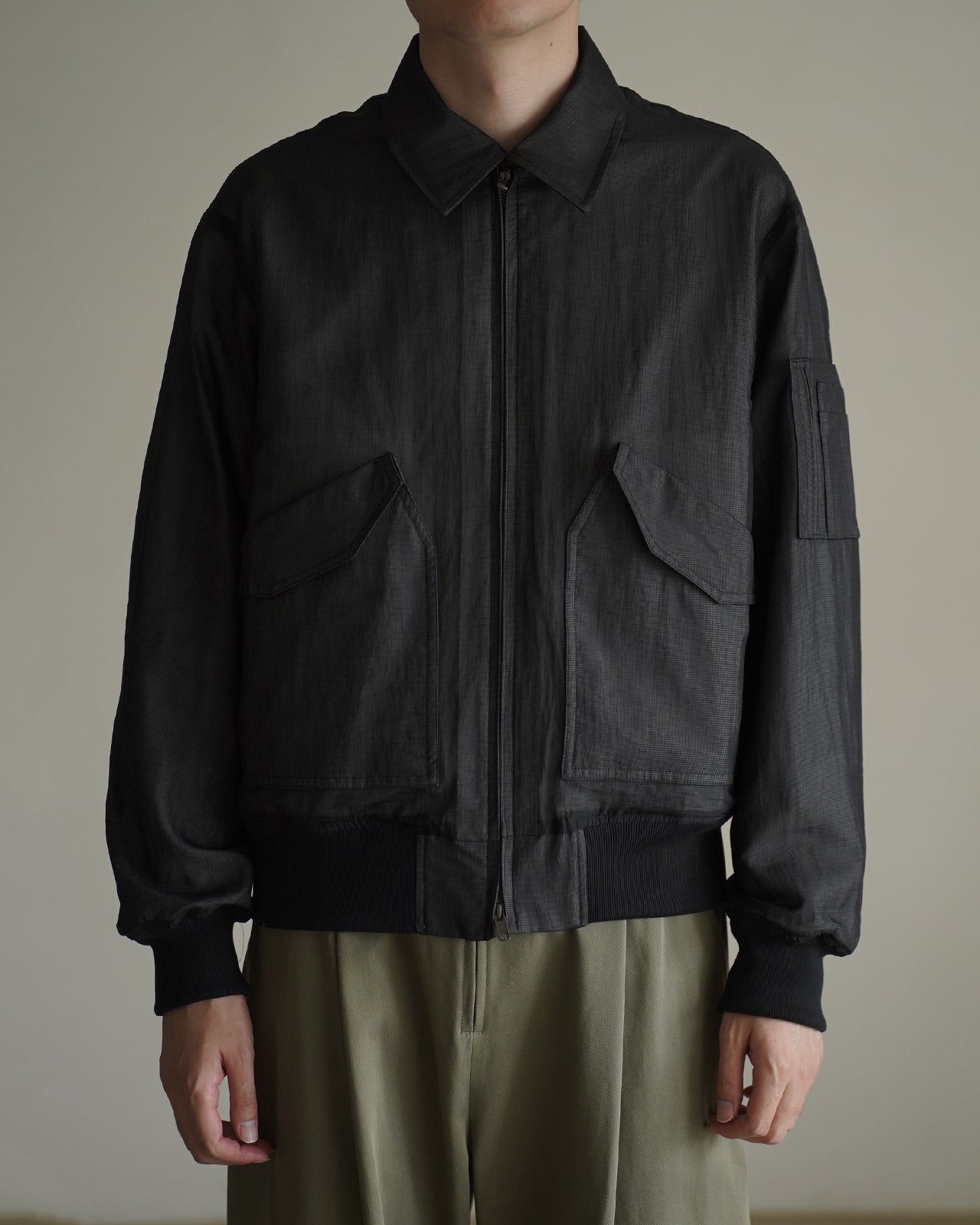 黒の Veiled Flight Jacket RM262-010の正面アップ。前立てとジップが中央にあり、胸元はスッキリとしたシルエット。