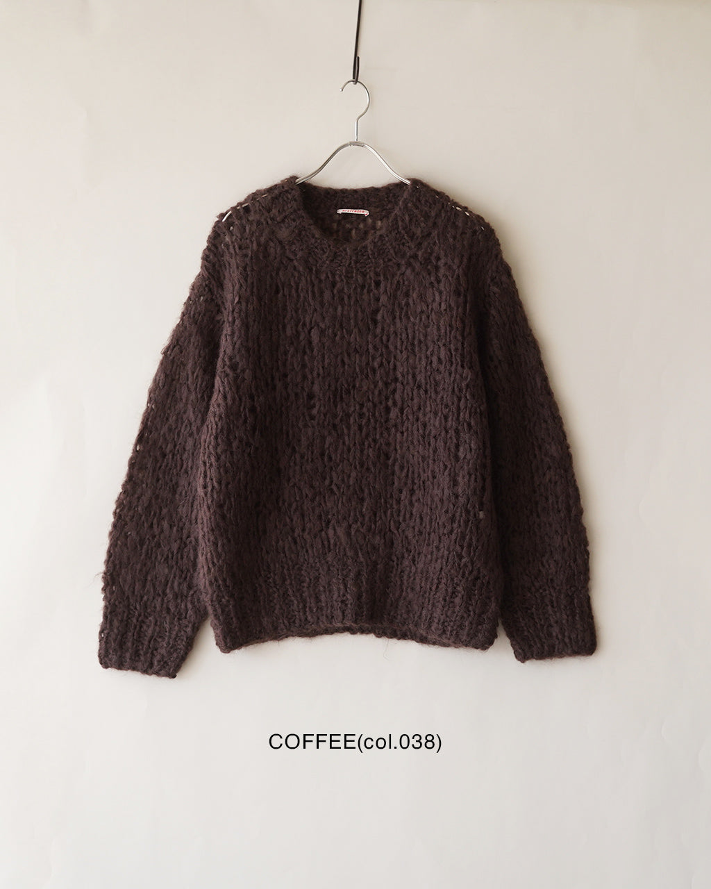 暗いコーヒー色のざっくり編みニット。ややゆったりとしたシルエットで、クルーネックと長めの袖が特徴的なプルオーバー。