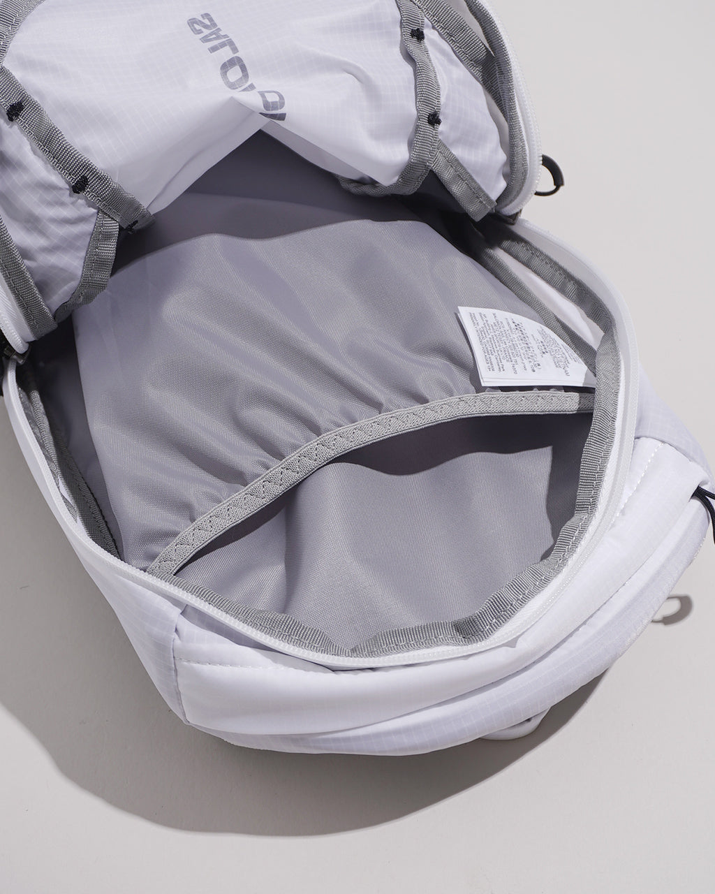 ホワイト系の背面入口が開いたXT10 BACKPACKの内部をアップで撮影。容量約10Lのオーガナイザーとパッド入りバックパネルが見える。