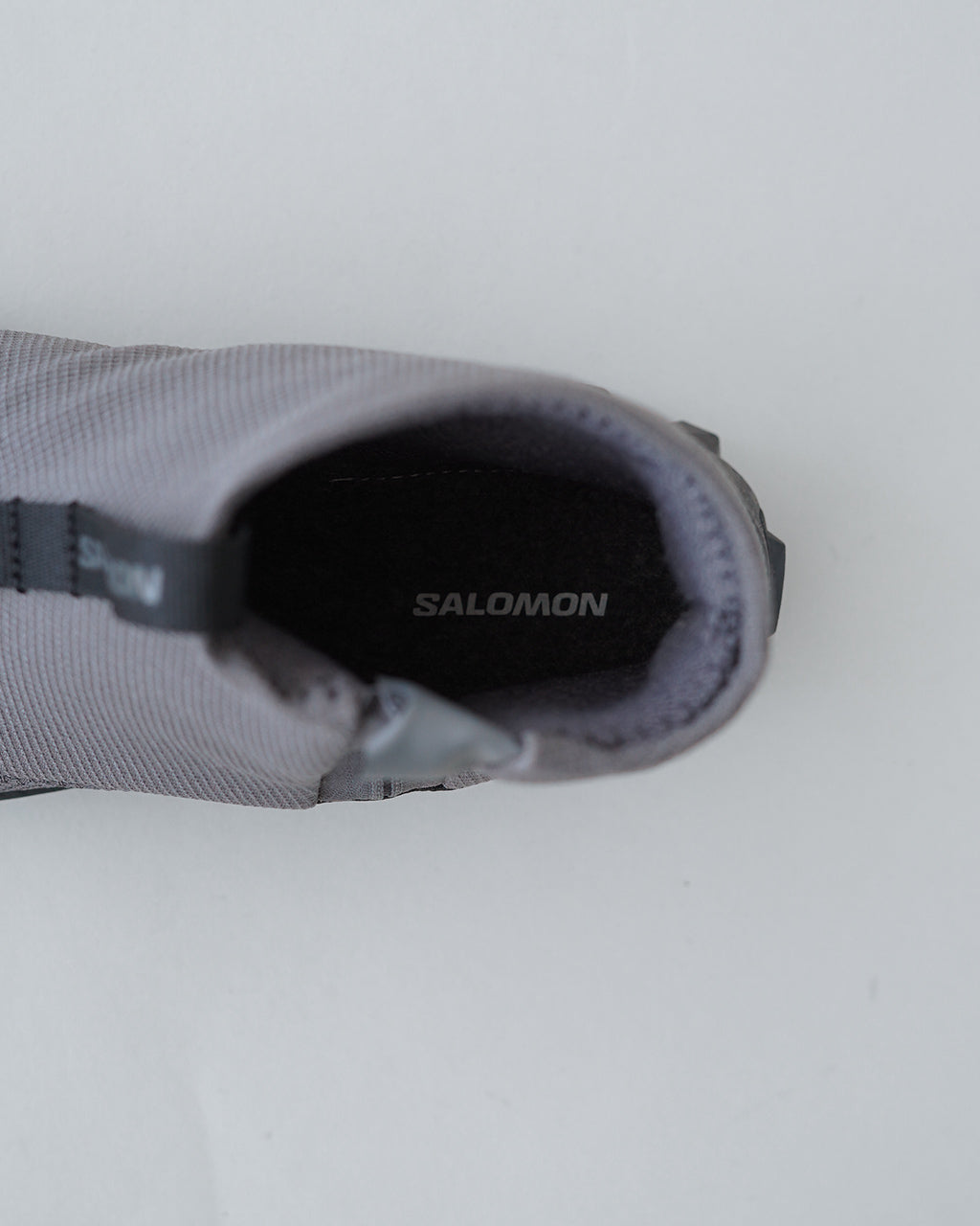 サロモン SNOWCLOG MID の内側を上からのぞくショット。グレー系の生地とブランドロゴのSALOMONが見える。