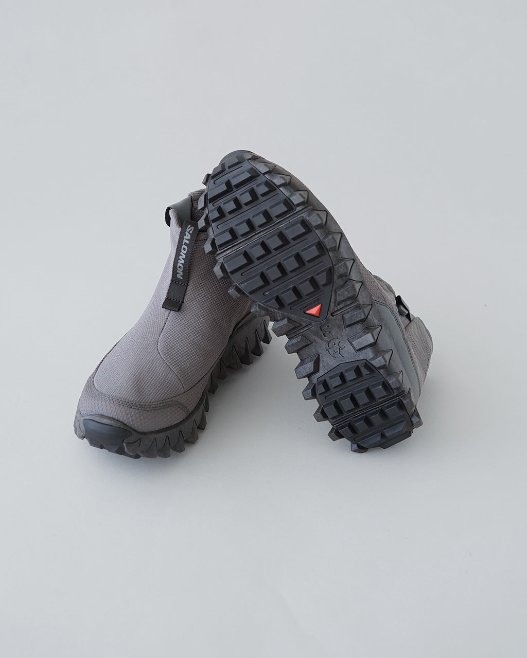 SALOMONの雪道対応ブーツ。グレーのアッパーと厚いラグ状ソールが特徴で、サイドジップ風のデザインが見える。全体的にボリュームのあるシルエットと滑りにくいアウトソールパターンが印象的。