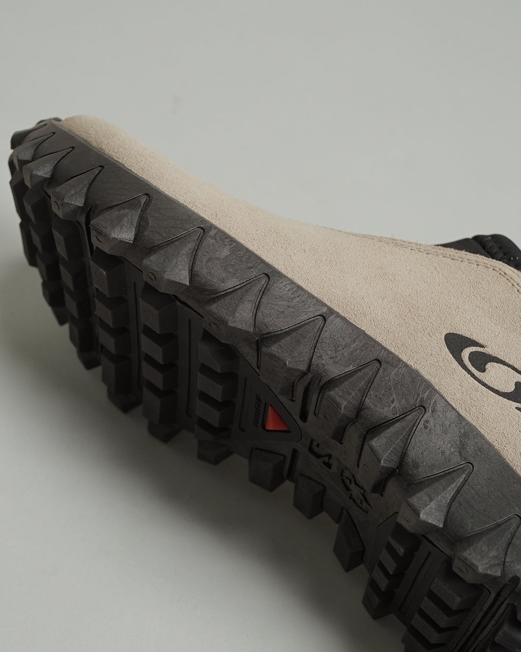 サロモン SNOWCLOG OG のアッパーを近接撮影。ベージュ系カラーの素材感と荒い質感の表現、黒いアウトソールの厚みと凹凸パターンが特徴的なディテールショット