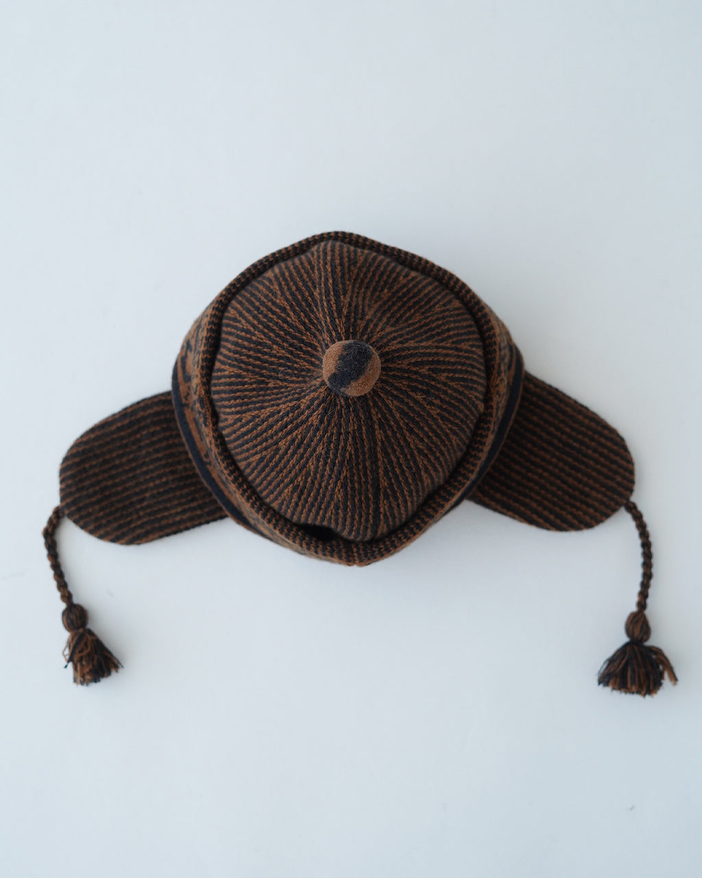 ブラウン系の編み込み柄が映える Pakisani Knit Cap。前後の丸みとつば状の耳周りアクセントが特徴のニット帽子。柔らかなウール素材で、伝統的な柄を現代風に表現したデザインです。