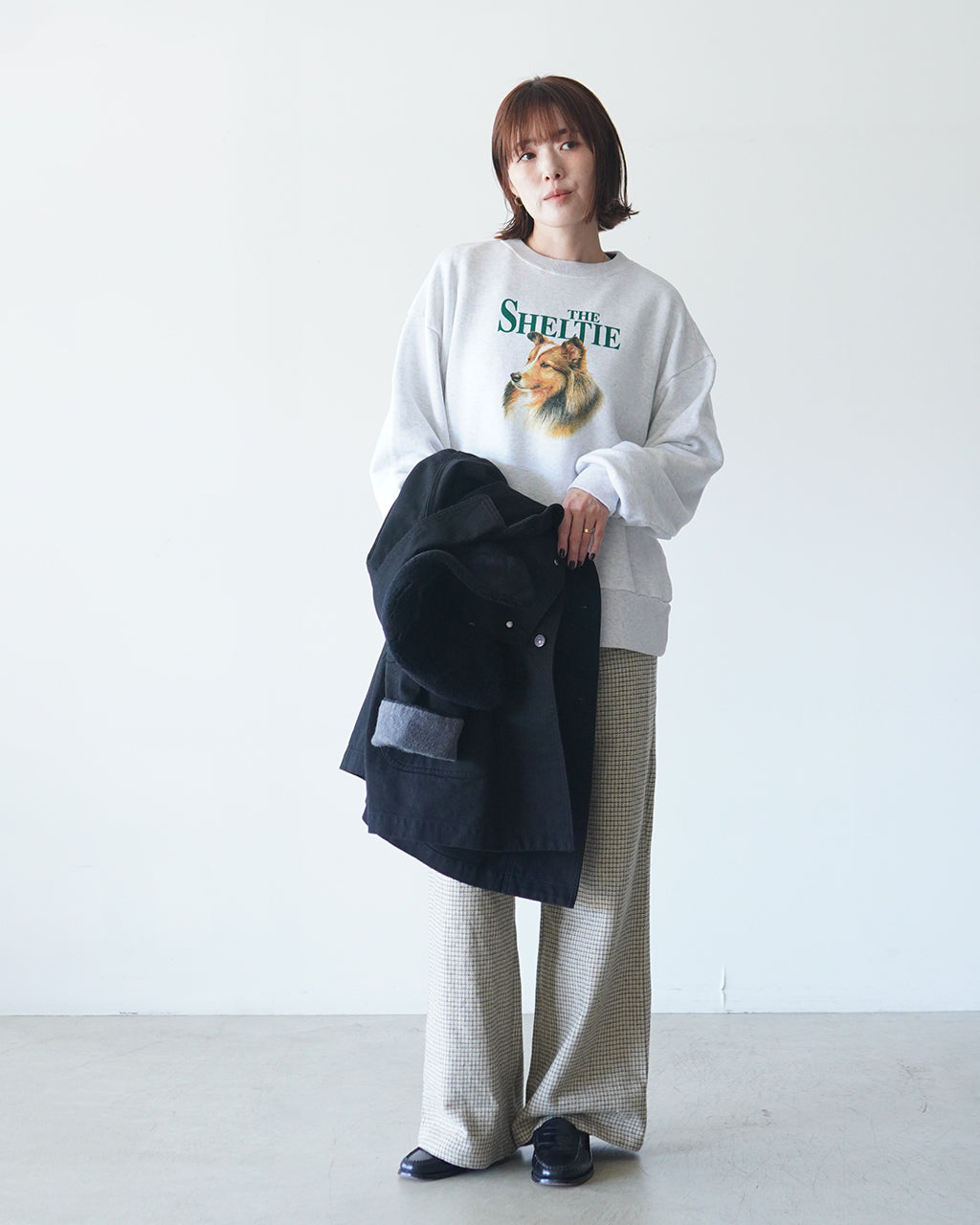 THE SHINZONEの「THE SHELTIE SWEATSHIRT」白系のスウェットにシェットランド犬のモチーフとロゴがプリントされ、リラックスした着用感のモデル写真