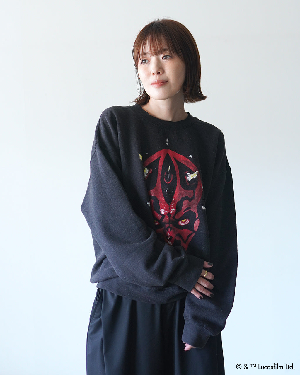 黒地にダース・モールのプリントが入った裏起毛スウェット。ゆったりとしたシルエットで袖口と裾がリブ仕様、前方に配置された大きめのデザインが目を引く着用イメージ。